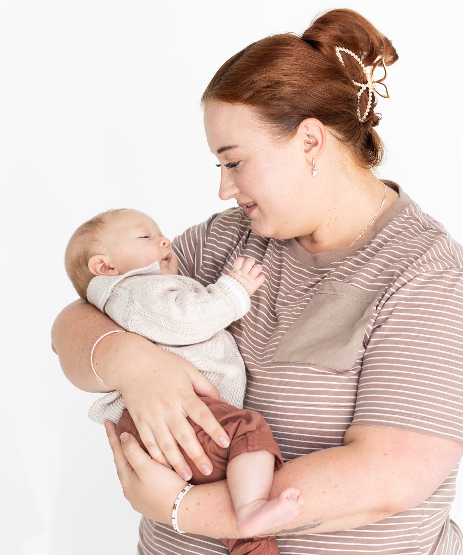 Mum cuddling her baby in the brown and white striped Mackenzie breastfeeding tee by Milky Threads Co