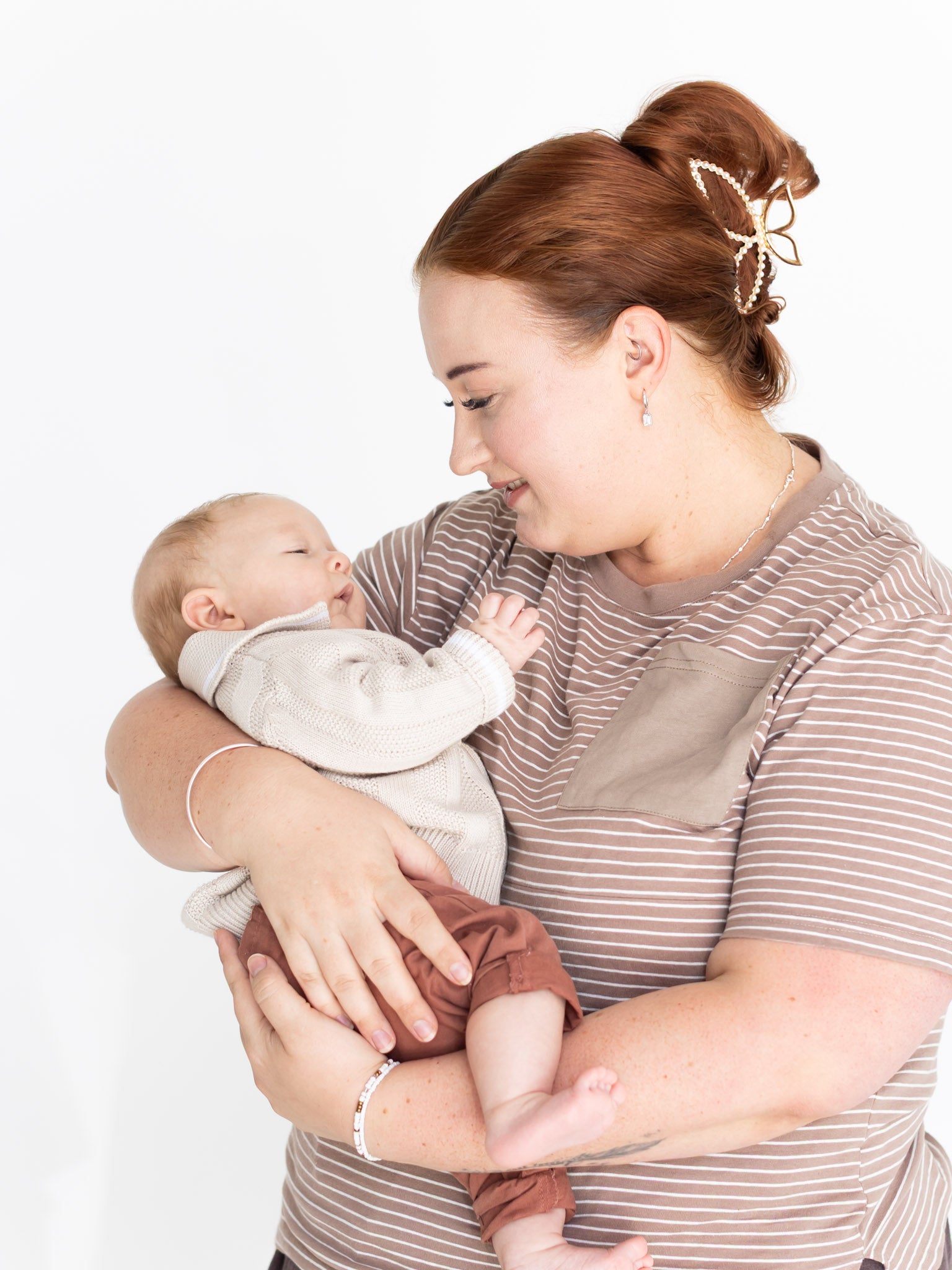 Mum cuddling her baby in the brown and white striped Mackenzie breastfeeding tee by Milky Threads Co
