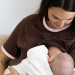 Mum breastfeeding her newborn in the brown and pink Indiana tee
