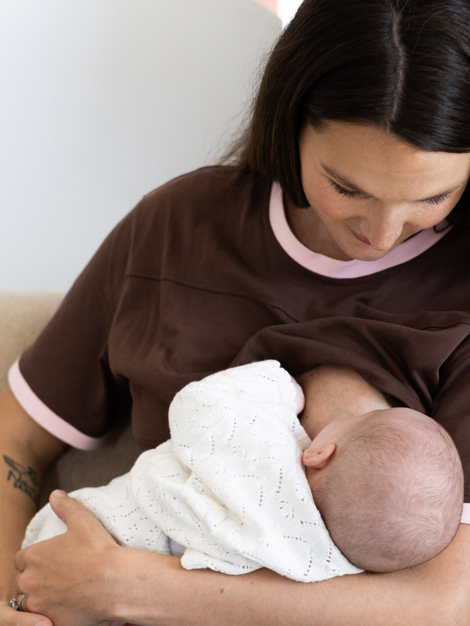 Mum breastfeeding her newborn in the brown and pink Indiana tee