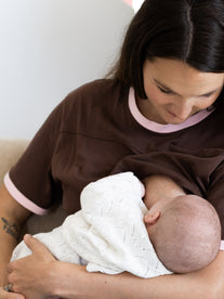 Mum breastfeeding her newborn in the brown and pink Indiana tee