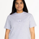 Front view of the Indiana breastfeeding tee in light grey, worn oversized with jeans
