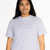 Front view of the Indiana breastfeeding tee in light grey, worn oversized with jeans