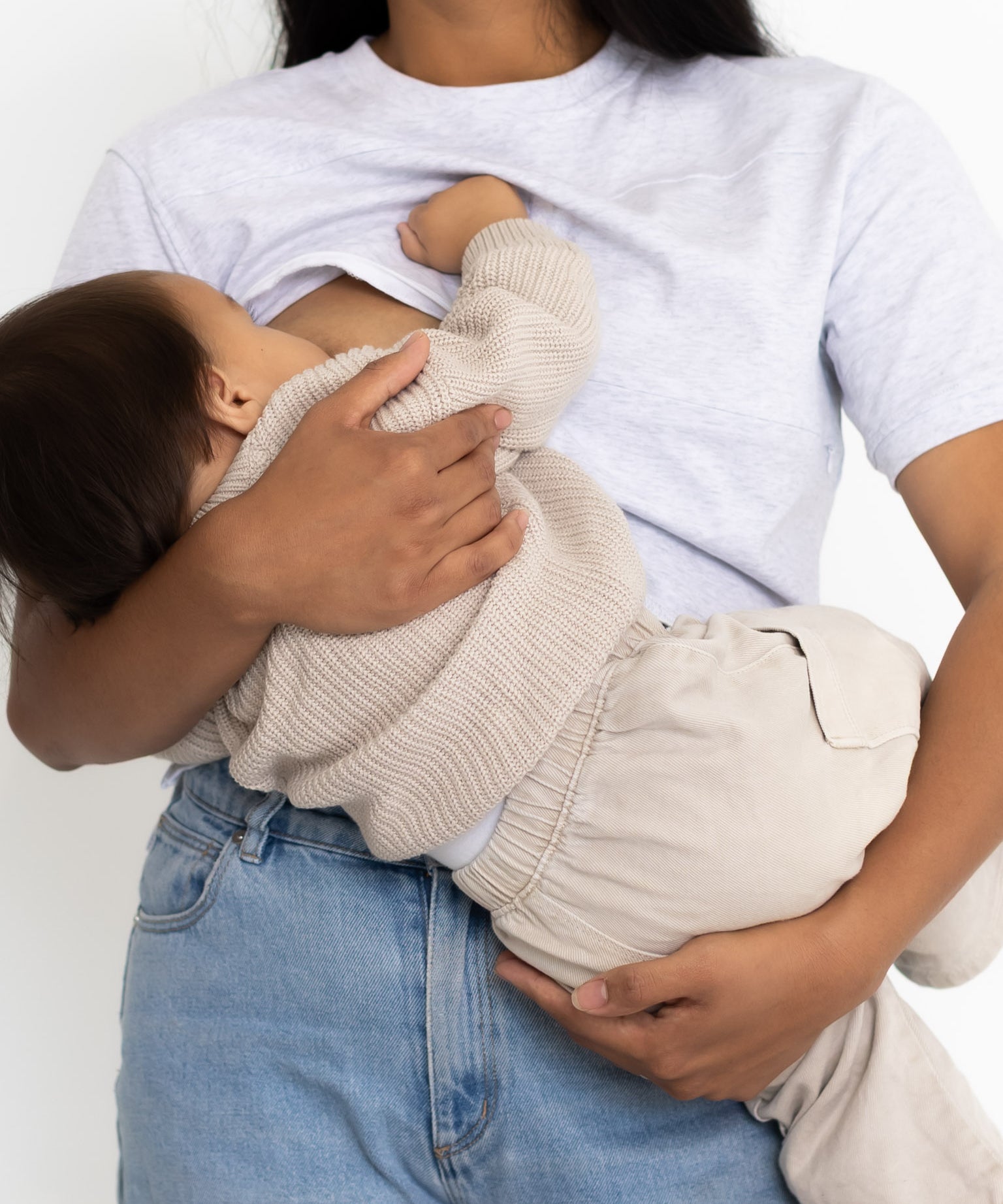 Mum breastfeeding her baby in the light grey Indiana breastfeeding tee by Milky Threads Co, worn with jeans