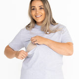 Smiling mum opening the discreet two-way zip on the light grey Indiana breastfeeding tee