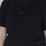Close-up of the Milky Threads Co flower logo and panel detail on the black Indiana tee