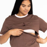 Mum opening the discreet two-way zip on the brown Indiana breastfeeding tee with pink trim