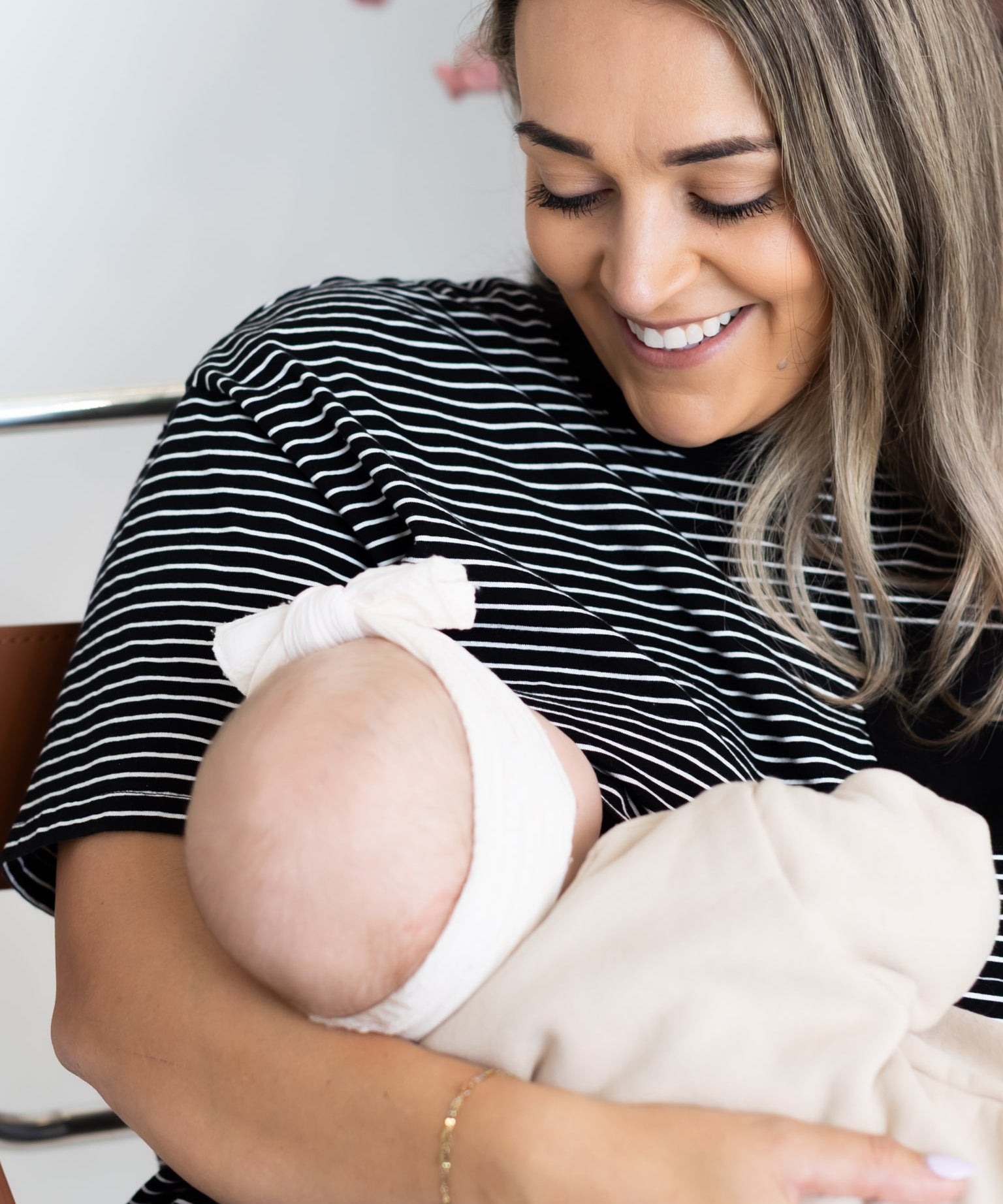 Smiling mum breastfeeding her baby in the black and white striped Mackenzie breastfeeding tee by Milky Threads Co
