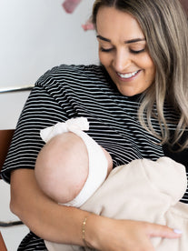 Smiling mum breastfeeding her baby in the black and white striped Mackenzie breastfeeding tee by Milky Threads Co