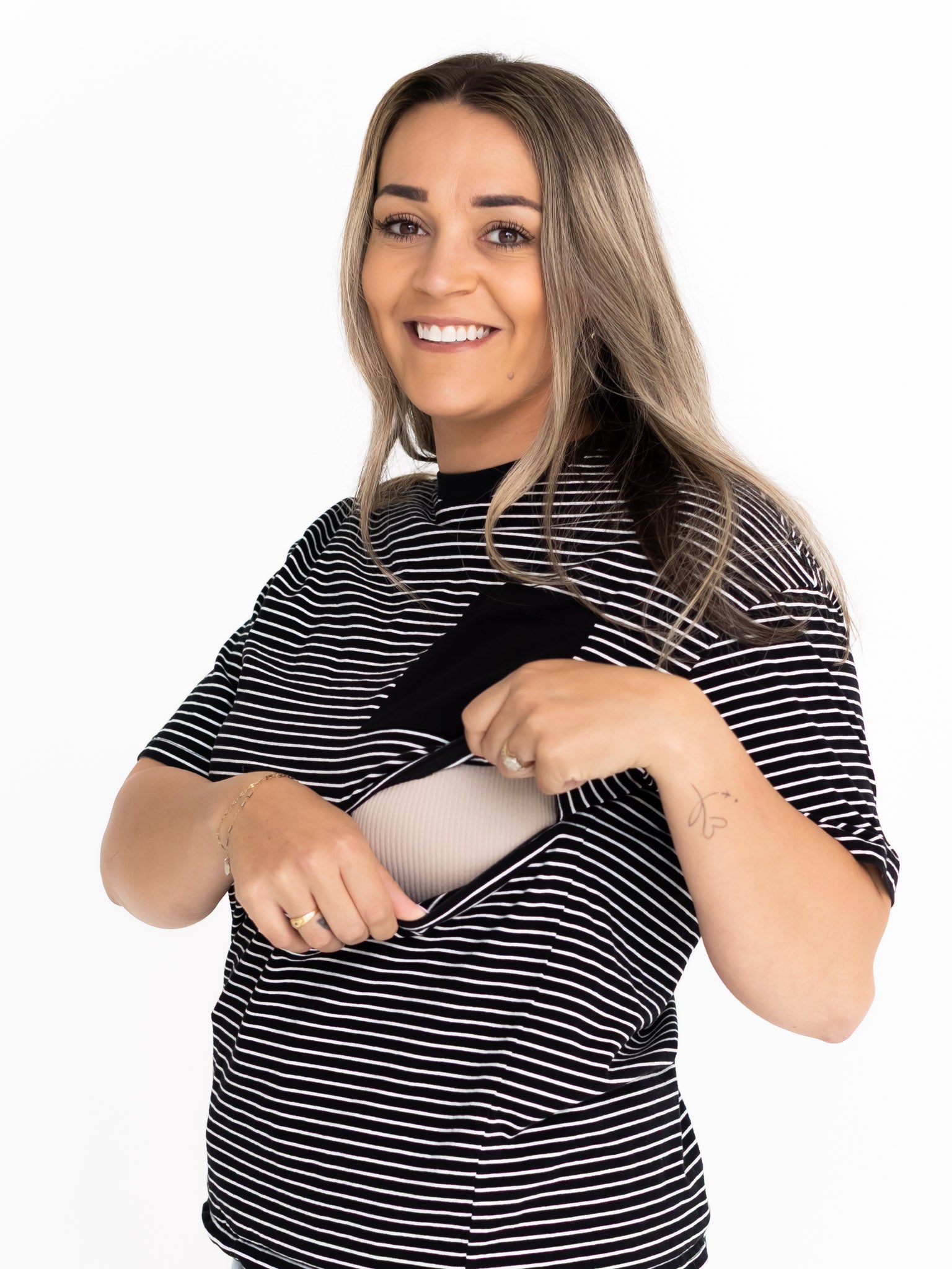 Smiling mum opening the two-way zip on the striped Mackenzie breastfeeding tee